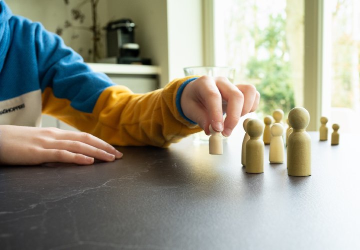 Kinderhand verplaatst houten figuren op tafel