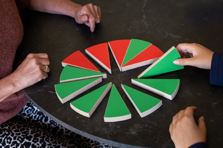 Handen van coach en jongere bij gekleurde kaartjes op tafel